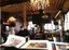 Artist studio workspace - fine art conservator reviewing original contemporary paintings and prints in rustic atelier with exposed beams