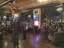 Corporate event in brick-walled venue with guests seated in conversation area, featuring large screen displays and professional event production equipment for presentations and interviews